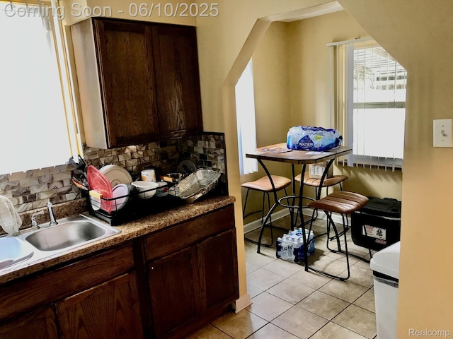 5782 Haverhill St, Detroit, MI 48224 - kitchen with tasteful backsplash, light tile patterned floors, a sink, and dark brown cabinets