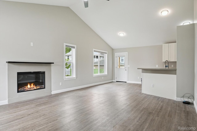 1759 2nd St, Taylor, MI 48192 - unfurnished living room featuring a ceiling fan, wood finished floors, a sink, high vaulted ceiling, and a glass covered fireplace