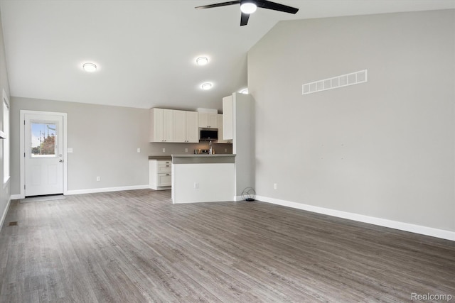 1759 2nd St, Taylor, MI 48192 - unfurnished living room featuring ceiling fan, wood finished floors, baseboards, and high vaulted ceiling