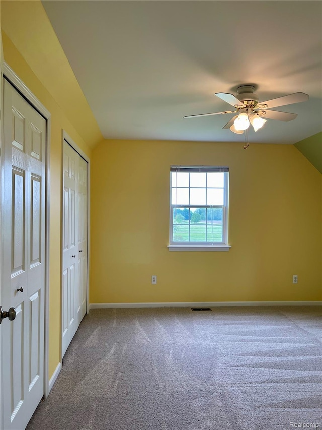 1325 Capac Rd, Berlin, MI 48002 - unfurnished bedroom featuring vaulted ceiling, two closets, carpet floors, baseboards, and a ceiling fan