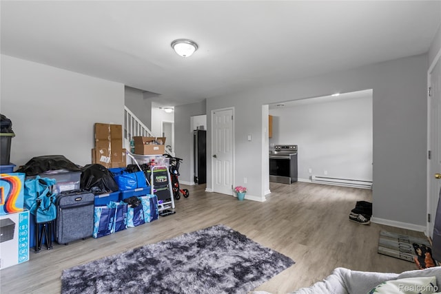 18625 Carrie St, Detroit, MI 48234 - living room featuring a baseboard radiator, wood finished floors, stairs, and baseboards