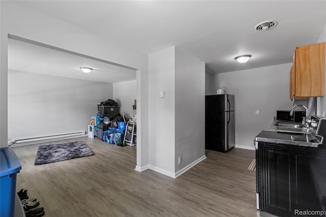 18625 Carrie St, Detroit, MI 48234 - kitchen featuring freestanding refrigerator, a baseboard heating unit, wood finished floors, a sink, and baseboards