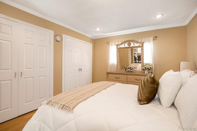 2263 Lawnel Ave, Norton Shores, MI 49441 - bedroom featuring light wood finished floors, ornamental molding, recessed lighting, and multiple closets