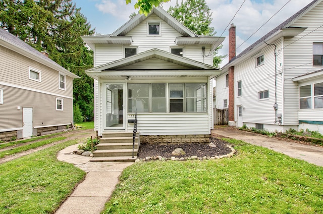 1118 Burr St, Jackson, MI 49201 - american foursquare style home featuring a sunroom, a front lawn, and entry steps