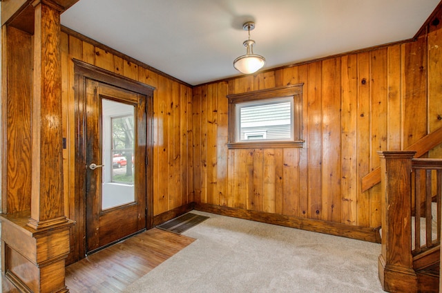1118 Burr St, Jackson, MI 49201 - foyer with healthy amount of natural light, carpet, wood walls, baseboards, and stairs