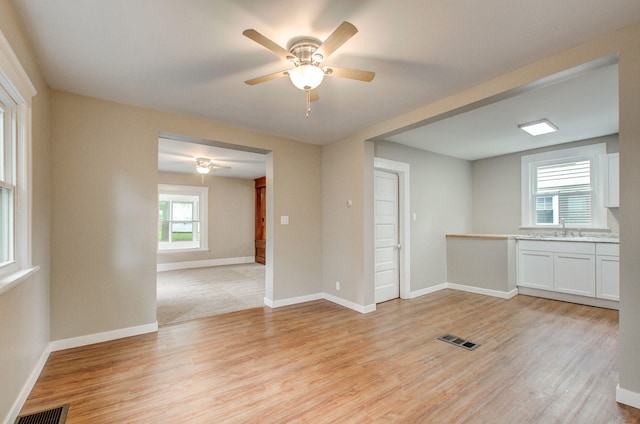 1118 Burr St, Jackson, MI 49201 - empty room with a sink, ceiling fan, light wood-type flooring, and baseboards