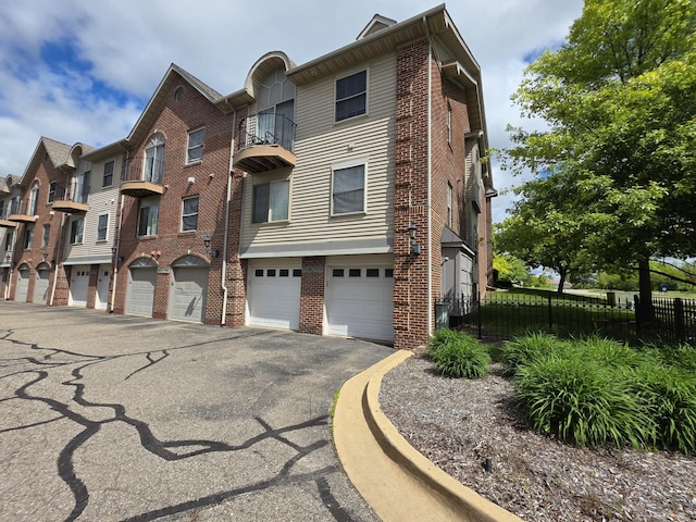 2936 Signature Blvd, Ann Arbor, MI 48103 - view of front of house featuring driveway, brick siding, a balcony, and an attached garage