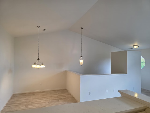2936 Signature Blvd, Ann Arbor, MI 48103 - spare room with vaulted ceiling, wood finished floors, a chandelier, and baseboards