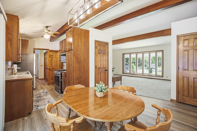 15035 155th Ave, Grand Haven, MI 49417 - dining room with beamed ceiling, light wood finished floors, ceiling fan, and baseboards