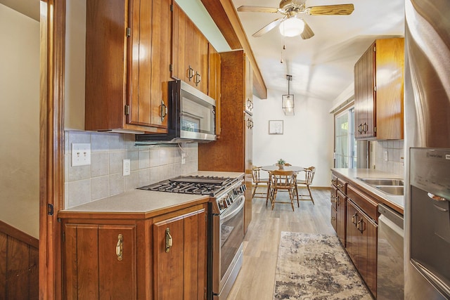 15035 155th Ave, Grand Haven, MI 49417 - kitchen with appliances with stainless steel finishes, brown cabinets, tasteful backsplash, light wood-style floors, and light countertops