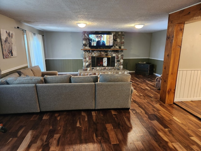 19354 Dutch Settlement St, Cassopolis, MI 49031 - living area featuring a wainscoted wall, a textured ceiling, a fireplace, and dark wood-style floors