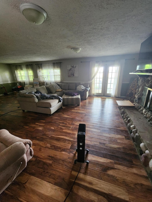19354 Dutch Settlement St, Cassopolis, MI 49031 - living area featuring hardwood / wood-style floors, a textured ceiling, a stone fireplace, and french doors