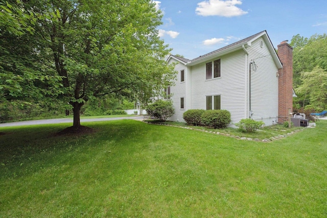 16350 Whitaker Rd, Linden, MI 48451 - view of home's exterior with a chimney, a yard, and central AC