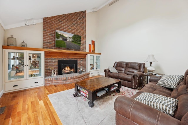 16350 Whitaker Rd, Linden, MI 48451 - living room featuring crown molding, lofted ceiling, wood finished floors, a fireplace, and baseboards