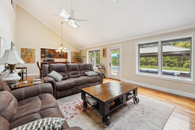16350 Whitaker Rd, Linden, MI 48451 - living area with plenty of natural light, a chandelier, high vaulted ceiling, baseboards, and light wood-style floors