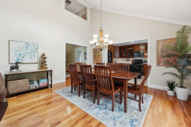 16350 Whitaker Rd, Linden, MI 48451 - dining space with a chandelier, light wood finished floors, baseboards, and high vaulted ceiling