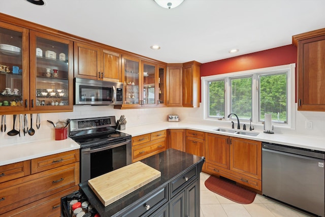 16350 Whitaker Rd, Linden, MI 48451 - kitchen with appliances with stainless steel finishes, a sink, backsplash, brown cabinetry, and light countertops