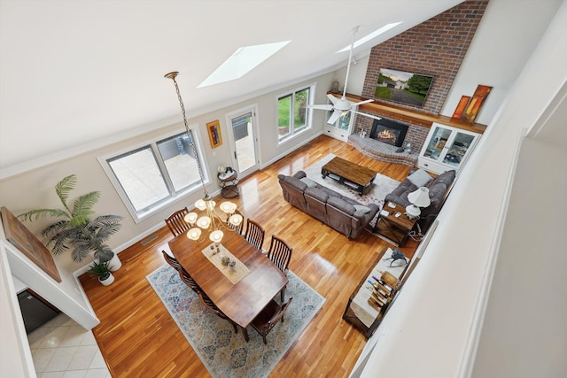 16350 Whitaker Rd, Linden, MI 48451 - living room featuring lofted ceiling, a skylight, a fireplace, wood finished floors, and baseboards