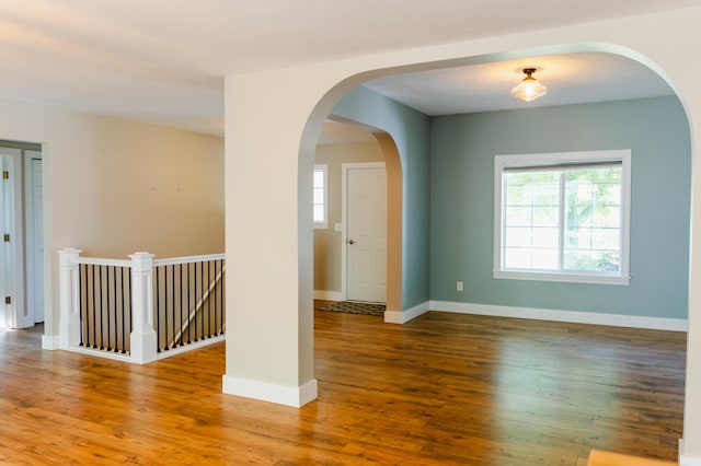 11775 Crystal Ridge Dr NE, Sparta, MI 49345 - unfurnished room with healthy amount of natural light, wood finished floors, baseboards, and arched walkways