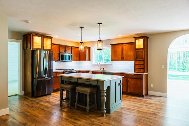 11775 Crystal Ridge Dr NE, Sparta, MI 49345 - kitchen with stainless steel appliances, a sink, baseboards, light countertops, and a kitchen island