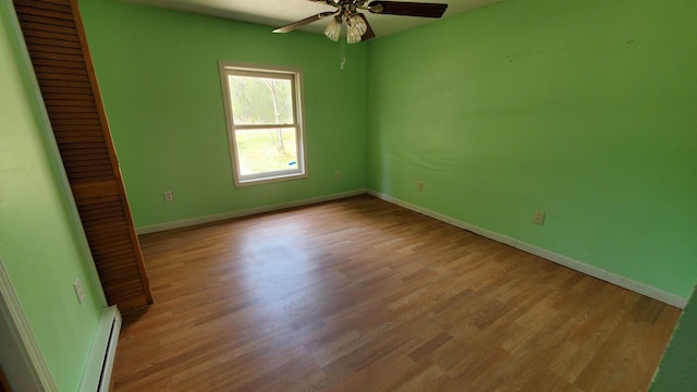 599 Ruby Rd, Sheridan, MI 48884 - spare room featuring baseboard heating, a ceiling fan, baseboards, and wood finished floors