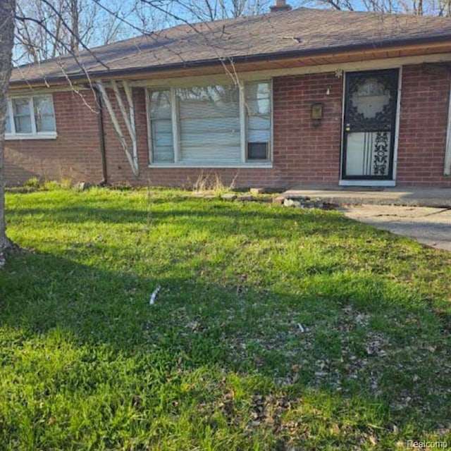 28632 Hazelwood St, Detroit, MI 48141 - view of exterior entry featuring brick siding and a yard