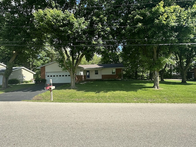 388 Richard St, Spring Arbor, MI 49283 - single story home with driveway, a front yard, a garage, and view of wooded area
