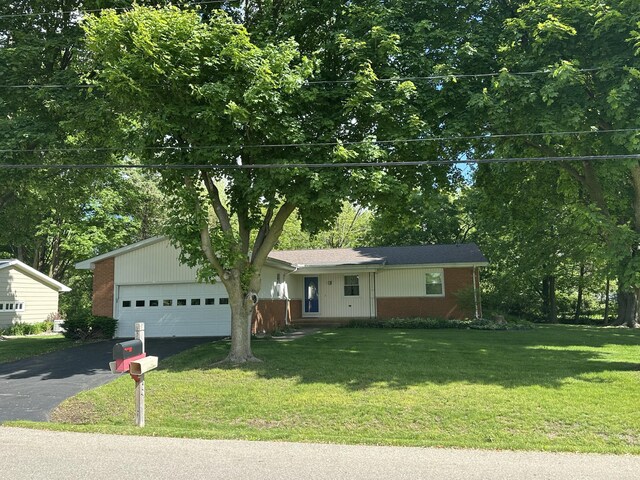 388 Richard St, Spring Arbor, MI 49283 - view of front of house featuring driveway, brick siding, a garage, a front lawn, and view of scattered trees