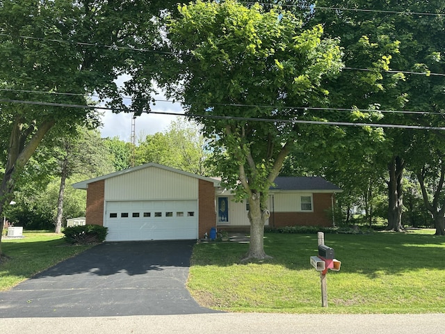 388 Richard St, Spring Arbor, MI 49283 - view of front facade with driveway, brick siding, a front yard, a garage, and view of wooded area