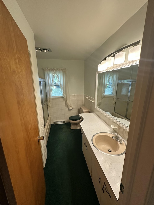 388 Richard St, Spring Arbor, MI 49283 - full bath with tile walls, vanity, toilet, wainscoting, and shower / bath combination with glass door