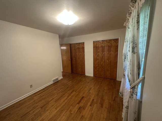 388 Richard St, Spring Arbor, MI 49283 - unfurnished bedroom with wood finished floors, two closets, and baseboards