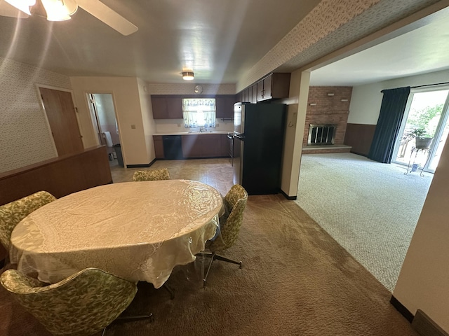 388 Richard St, Spring Arbor, MI 49283 - dining space featuring plenty of natural light, light colored carpet, ceiling fan, a brick fireplace, and wallpapered walls