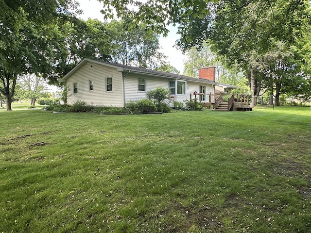 388 Richard St, Spring Arbor, MI 49283 - rear view of house with a chimney, a deck, and a lawn
