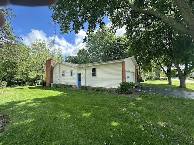 388 Richard St, Spring Arbor, MI 49283 - ranch-style home with a front lawn, a chimney, an attached garage, and central AC unit