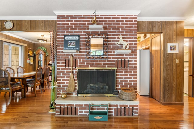 11676 Bradley Dr, Jerome, MI 49249 - living room with wooden walls, ornamental molding, wood finished floors, and a fireplace
