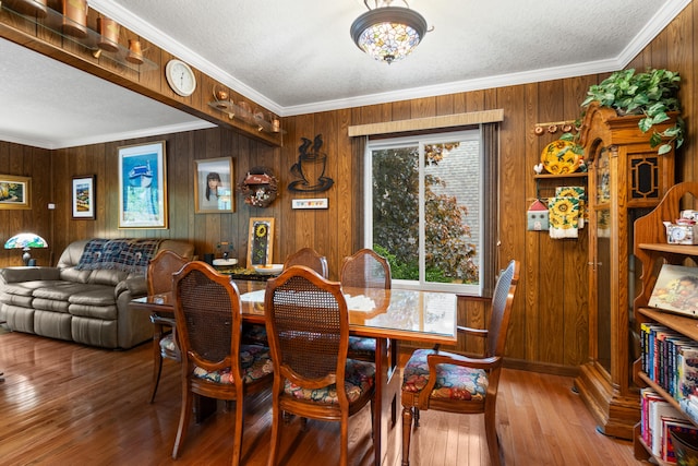 11676 Bradley Dr, Jerome, MI 49249 - dining area featuring crown molding, wooden walls, hardwood / wood-style floors, and baseboards
