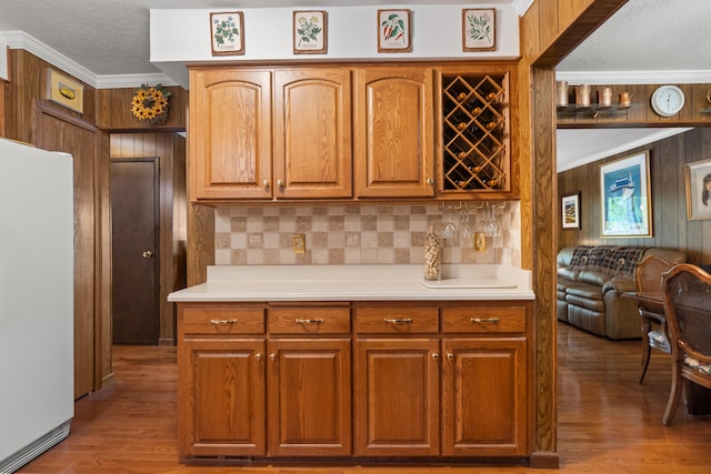 11676 Bradley Dr, Jerome, MI 49249 - kitchen featuring white refrigerator, a textured ceiling, wood walls, ornamental molding, and light countertops