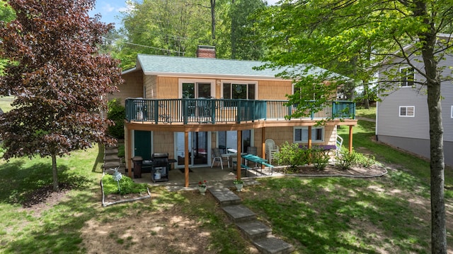 11676 Bradley Dr, Jerome, MI 49249 - back of property with a patio area, a wooden deck, a chimney, and a lawn