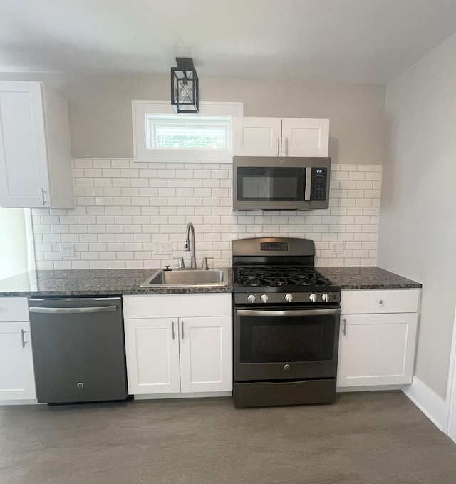1007 Alto Ave SE, Grand Rapids, MI 49507 - kitchen featuring stainless steel appliances, a sink, white cabinets, decorative backsplash, and dark stone countertops