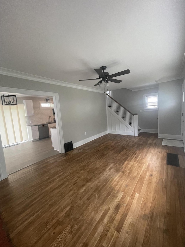 1007 Alto Ave SE, Grand Rapids, MI 49507 - unfurnished living room with crown molding, dark wood finished floors, a ceiling fan, baseboards, and a sink