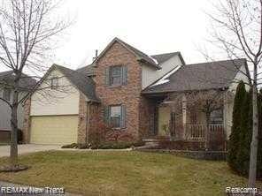 28765 Hearthstone Dr, Novi, MI 48377 - traditional-style house featuring a front yard, an attached garage, and driveway