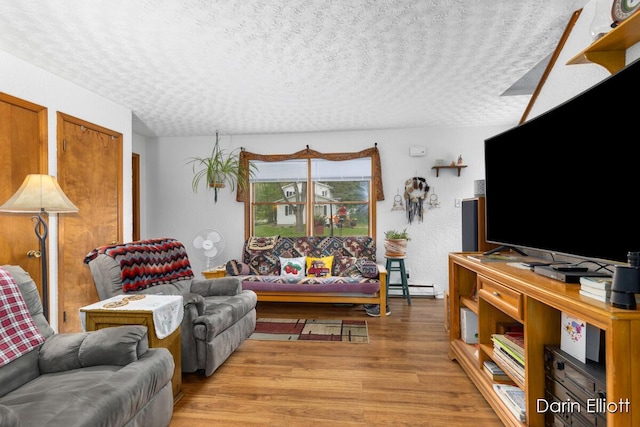 604/606 N New Dexter St, Ionia, MI 48846 - living area with light wood finished floors, a textured ceiling, and a baseboard radiator
