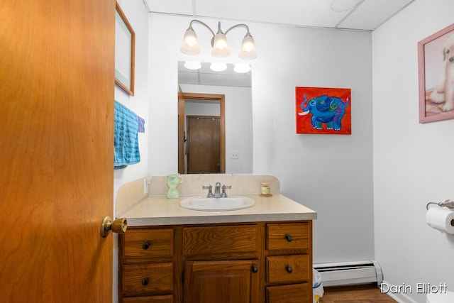 604/606 N New Dexter St, Ionia, MI 48846 - bathroom with baseboard heating, vanity, and wood finished floors