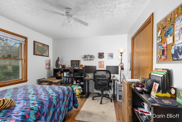 604/606 N New Dexter St, Ionia, MI 48846 - bedroom featuring wood finished floors, a textured ceiling, an office area, and a ceiling fan