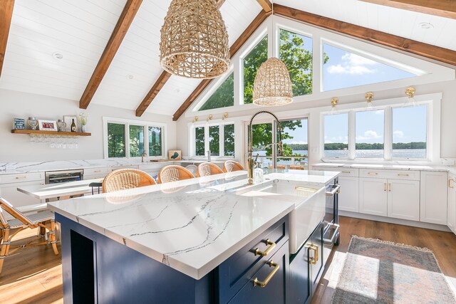 67881 Edgewater Beach Rd, White Pigeon, MI 49099 - kitchen featuring a sink, an island with sink, white cabinetry, light stone counters, and light wood-style floors
