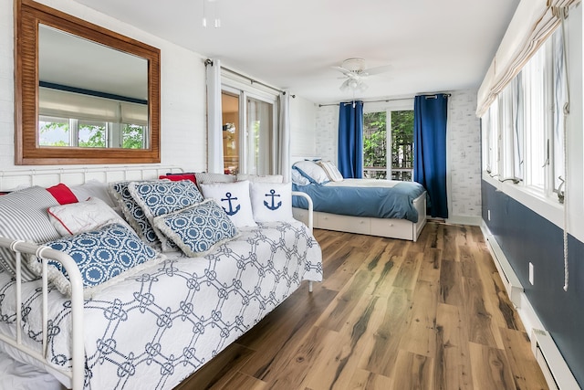 67881 Edgewater Beach Rd, White Pigeon, MI 49099 - bedroom featuring a baseboard heating unit, wood finished floors, a ceiling fan, baseboard heating, and baseboards
