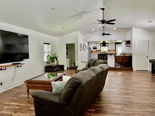 2985 Middle Lake Rd, Twin Lake, MI 49457 - living room with lofted ceiling, a ceiling fan, dark wood-style floors, and baseboards