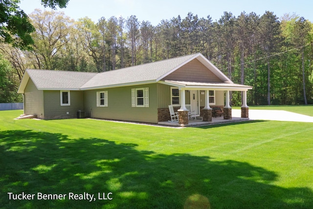 2985 Middle Lake Rd, Twin Lake, MI 49457 - view of front facade featuring covered porch, a front yard, cooling unit, and stone siding