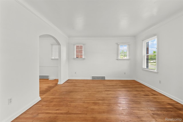 10576 Somerset Ave, Detroit, MI 48224 - unfurnished room with arched walkways, ornamental molding, light wood-style floors, and baseboards