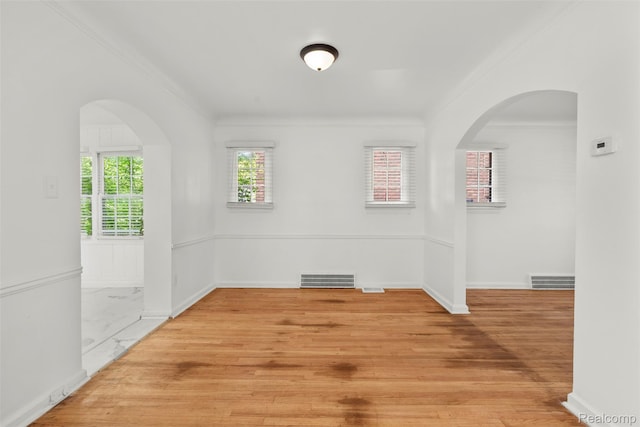 10576 Somerset Ave, Detroit, MI 48224 - unfurnished room featuring crown molding, baseboards, light wood-style flooring, and arched walkways